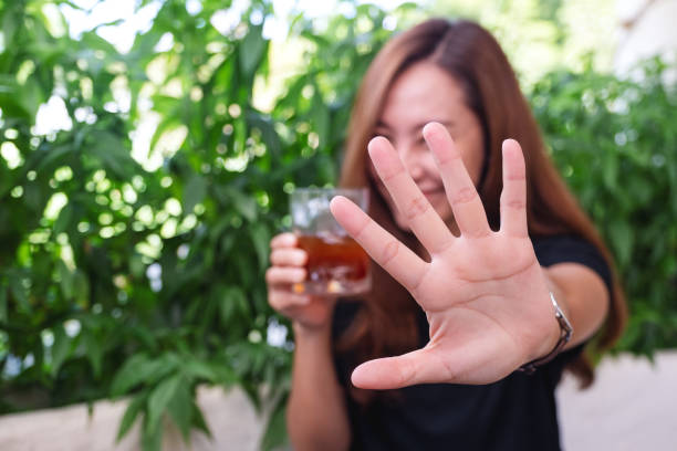 istock A woman raising hands and playing with camera while drinking iced coffee 1351435430