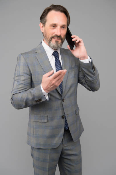 istock confident male talk on mobile phone. At work. trying to help someone. ceo in office jacket use smartphone. mature businessman answer email. professional business man in formal suit 1351435473
