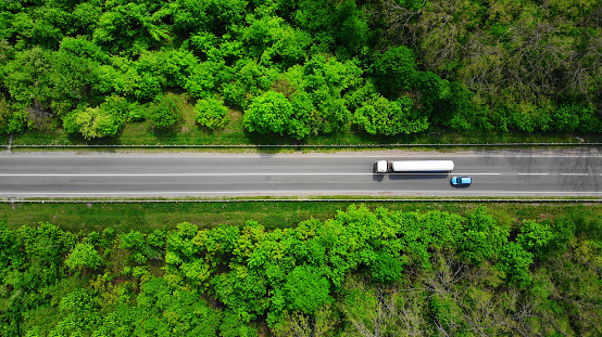 Aerial. Overtaking a truck by a passenger car. Top view from drone.