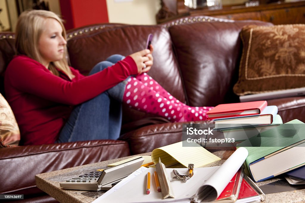 Adolescent portant ces chaussettes à pois canapé à envoyer des SMS sur téléphone portable - Photo de 16-17 ans libre de droits