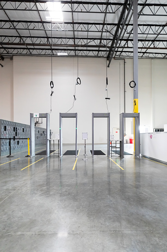 A line of four metal detectors at the entrance to a fulfillment center.
