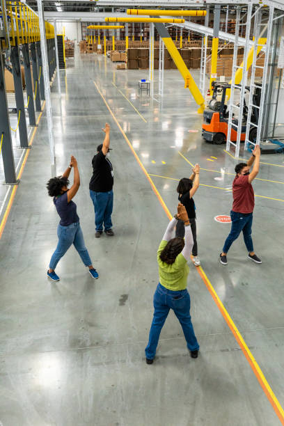 istock High Angle View of Warehouse Workers Stretching at Start of Shift 1351437777