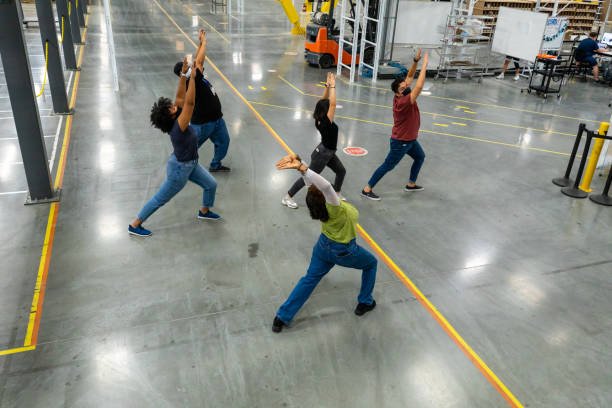 istock High Angle View of Woman Leading Stretching Routine for Warehouse Workers 1351437788