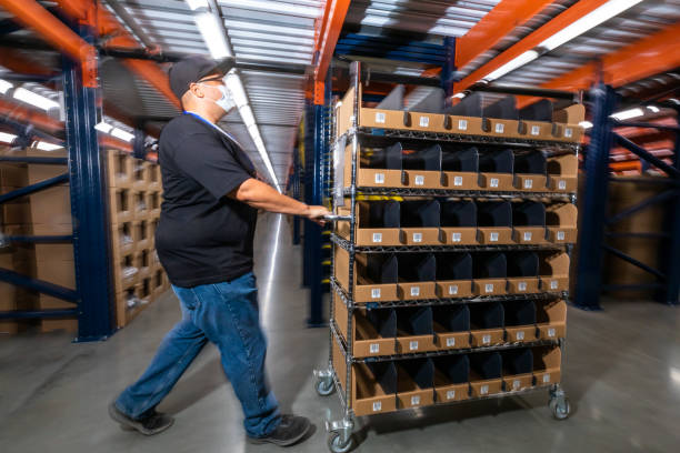 istock Worker Pushing Order Picking Cart Through Fulfillment Center 1351437801