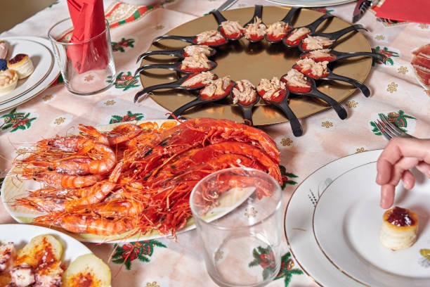 크리스마스 모티브가 있는 식탁보가 있는 테이블에 새우 플래터와 애피타이저 접시를 구워주세요. 가족 크리스마스 저녁 식사준비. - tuna food table dinner 뉴스 사진 이미지