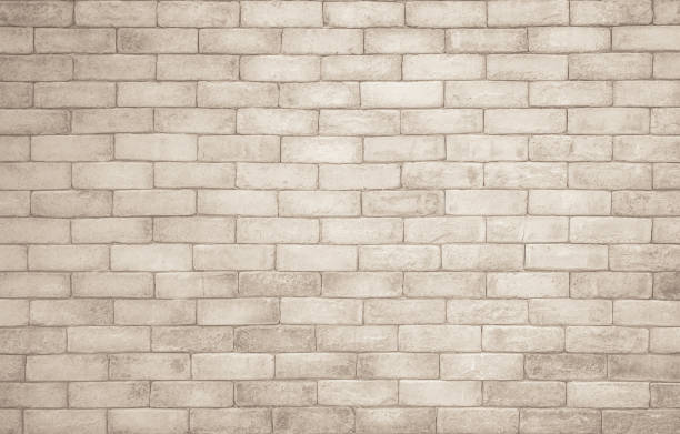 istock Cream and white brick wall texture background. Brickwork and stonework flooring interior rock old pattern clean concrete grid uneven bricks design stack. Background of old vintage brick wall 1351439423