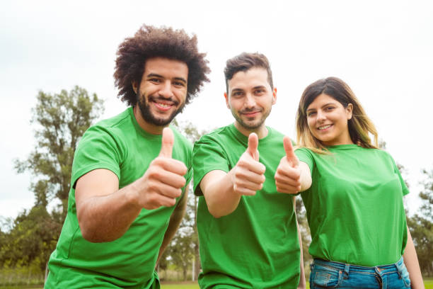 ambientalisti fiduciosi che mostrano il pollice in su - green t shirt foto e immagini stock