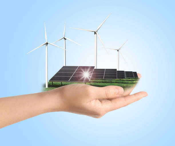 istock Woman demonstrating solar panel and wind turbines on light blue background, closeup. Alternative energy source 1351441198