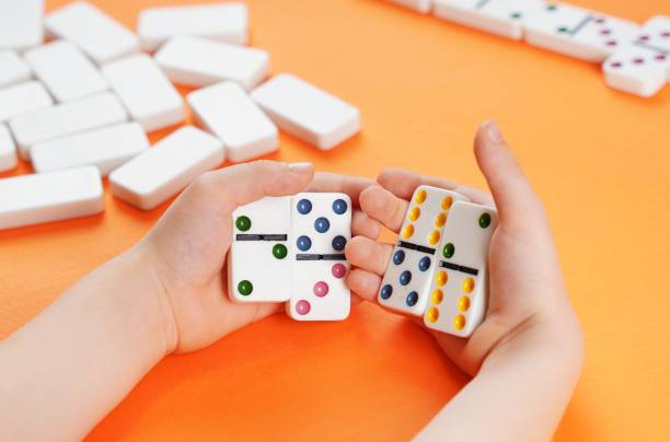 istock Domino game. Dominoes in children's hands. 1351442400
