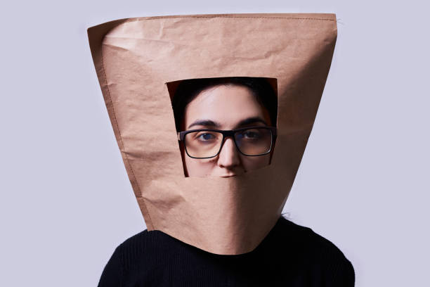 Multiracial woman in eyeglasses and wearing paper bag Multiracial woman in eyeglasses and wearing paper bag. Young woman with bad ugly hairs hiding her head with paper bag embarrassment unrecognizable person wearing a paper bag human head stock pictures, royalty-free photos & images