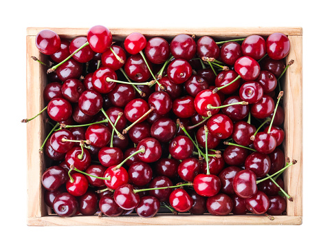 Sweet juicy cherries in crate on white background, top view