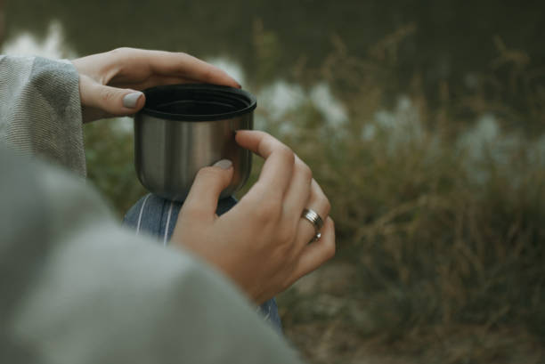 istock Female hands holding mug with hot drink 1351443552