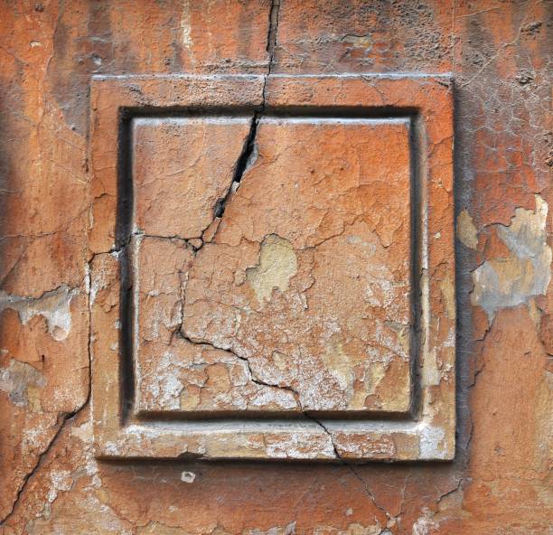 istock Framed square ornament surface with cracks and chipped orange painting from a weathered wall of an ancient house - texture for a background 1351443867
