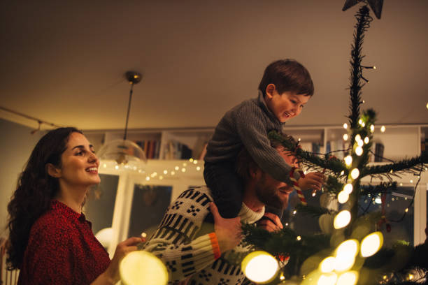 istock Small family decorating a Christmas tree together 1351444197