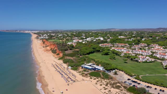 Aerial drone footage, shooting the tourist village of Vale de Lobo, on the shores of the Atlantic Ocean, golf courses for tourists. Portugal, Algarve.