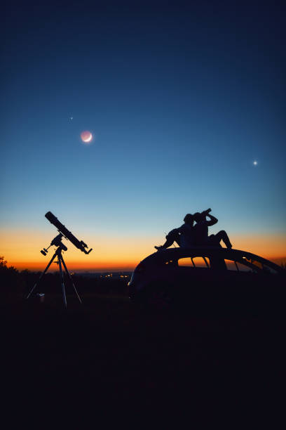 istock Couple stargazing together with a astronomical telescope. 1351446881
