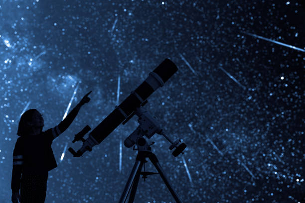 istock Girl with astronomical telescope stargazing under starry sky. 1351447301