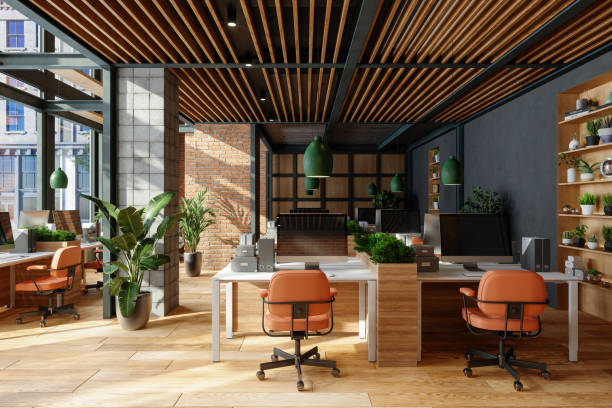 Umweltfreundliches offenes modernes Büro mit Tischen, Bürostühlen, Pendelleuchten und Pflanzen