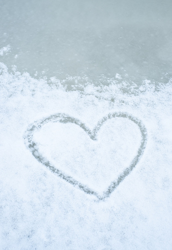 Heart shape drawn into snow on ice.