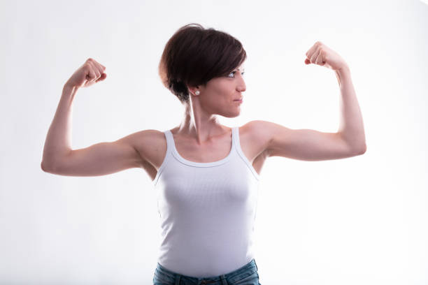 istock Fit young woman flexing her arms showing her biceps 1351449121
