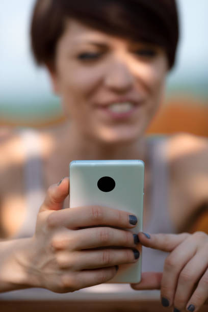 istock Young woman reading a message or watching media on a smartphone 1351449321