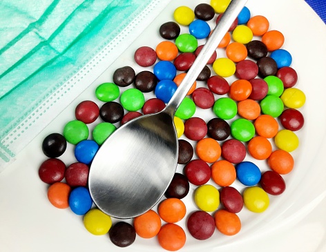 Eating Colorful Candy Snack using Spoon during Covid pandemic