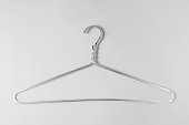 Metal clothes hanger in silver color on a gray background. Monochrome monochrome photo, horizontal, flat lay.