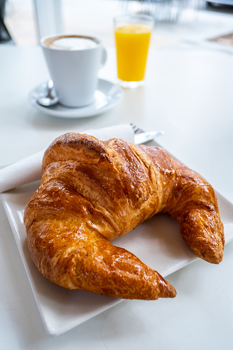 Coffee with milk, orange juice and croissant, real breakfast.