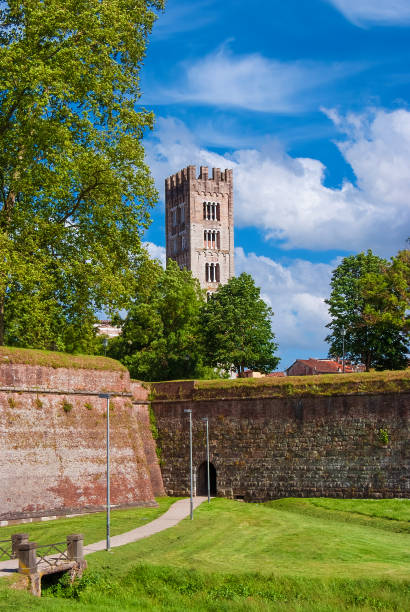 Lucca anciet walls at St Frediano Bulwark Lucca charming historical center. View of the iconic St Frediano medieval bell tower with ancient city walls lucca stock pictures, royalty-free photos & images