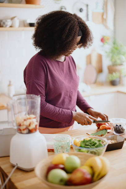 woman preparing fresh organic fruit smoothie - blender apple banana color image imagens e fotografias de stock