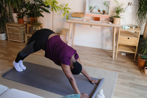 istock Young woman practicing yoga at home on video conference 1351452944