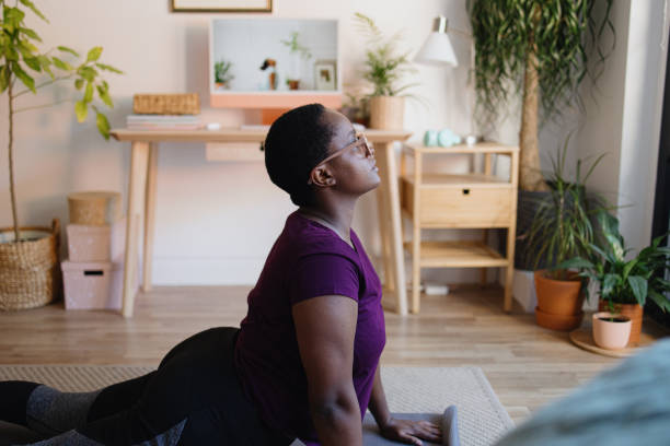 istock Young woman practicing yoga at home on video conference 1351452953