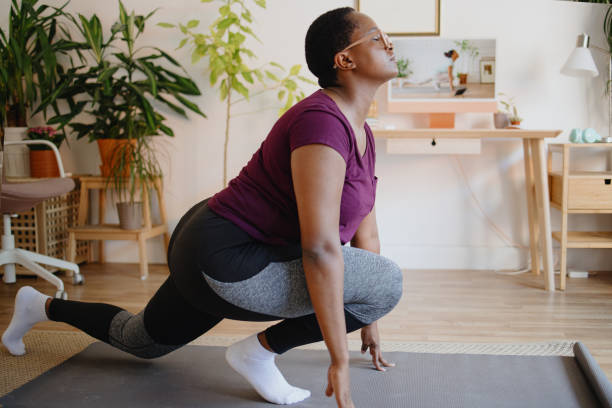 istock Young woman practicing yoga at home on video conference 1351453485
