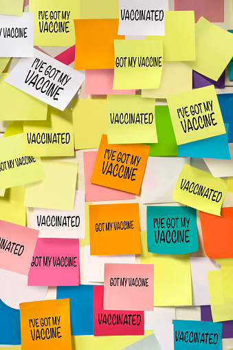 Adhesive notes with vaccination messages on a wall
