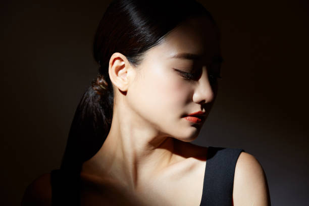 빛과 그림자에 젊은 아시아 여��성의 우아한 아름다움 초상화 - side view 이미지 뉴스 사진 이미지