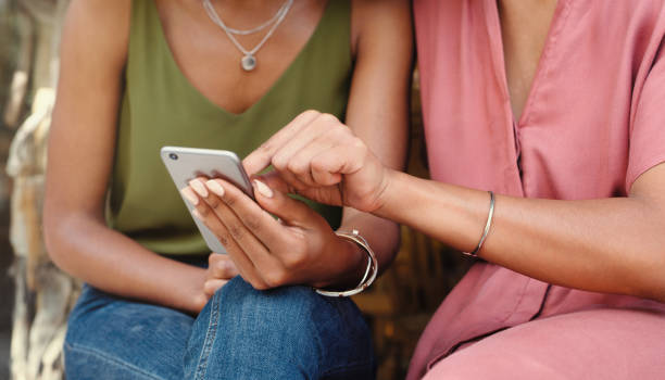 istock Shot of two unrecognizable friends using a phone together at a cafe 1351461082