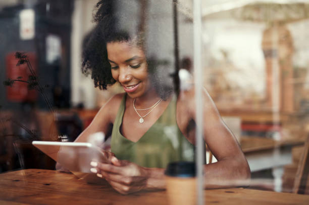 istock Shot of a young woman using a digital tablet at a cafe 1351461107
