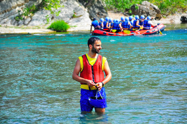 a group of male and female people doing for rafting on a clean river with a relatively calm water in a summer day for having fun leisure time activity sports concepts with copy space