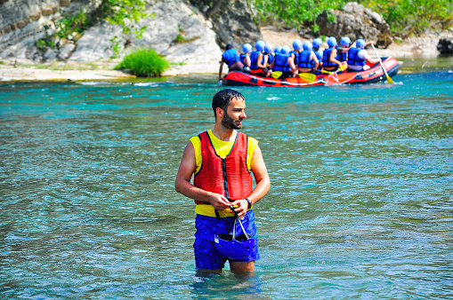 a group of male and female people doing for rafting on a clean river with a relatively calm water in a summer day for having fun leisure time activity sports concepts with copy space