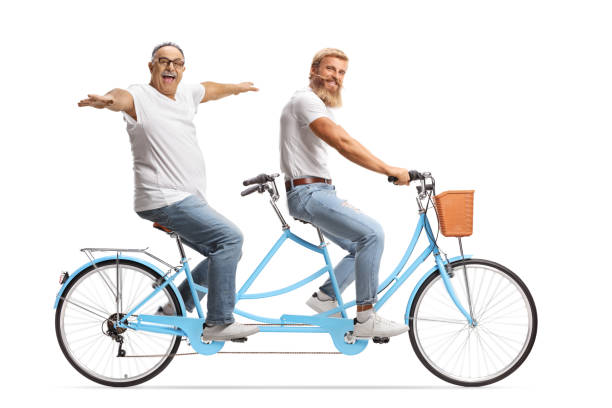 istock Young and mature man riding on a tandem bicycle with arms wide open 1351465335