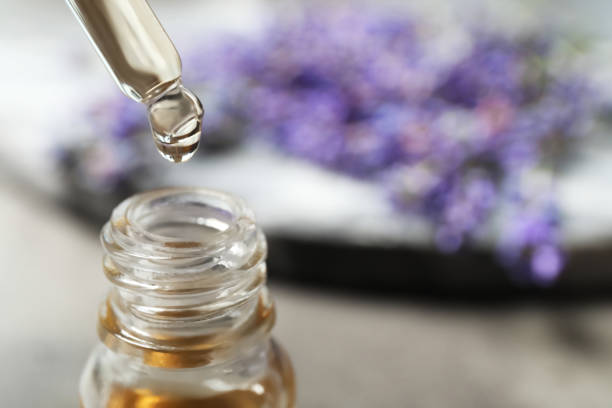 istock Dripping lavender essential oil into bottle, closeup. Space for text 1351465652