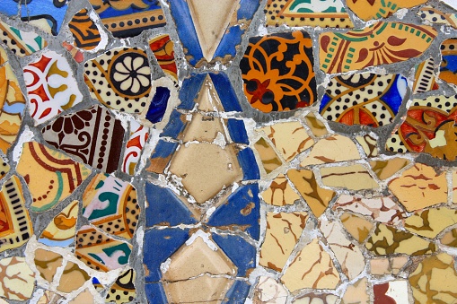 Barcelona colorful mosaic pattern by Antoni Gaudi. Modernist style ornament in Park Guell built between years 1900 and 1914. Currently a UNESCO World Heritage Site.