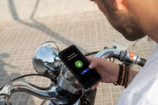 istock Man pays motorcycle rental with his mobile phone 1351467731
