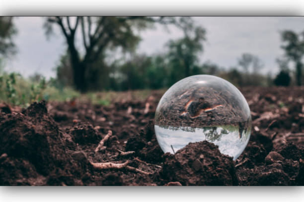 bola de cristal sentada en la superficie de la tierra - xero fotografías e imágenes de stock