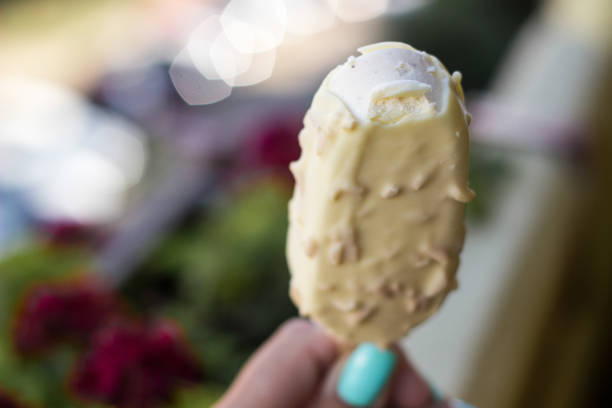 istock Young woman hand holding ice cream with white chocolate glaze 1351470849