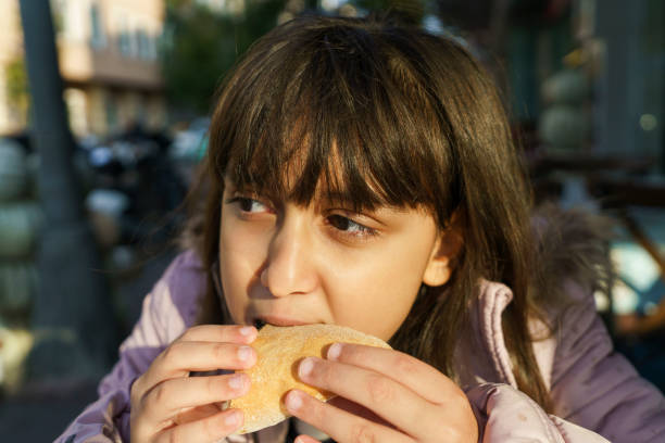 bella ragazza caucasica carina con hamburger - turkey burger immagine foto e immagini stock