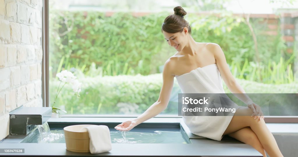 Woman holding hot spring water asian woman holding hot spring water in hands and feel it with smiling Shower Stock Photo