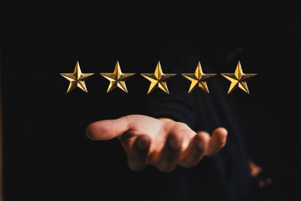 istock golden star rating on hand in dark background 1351472974