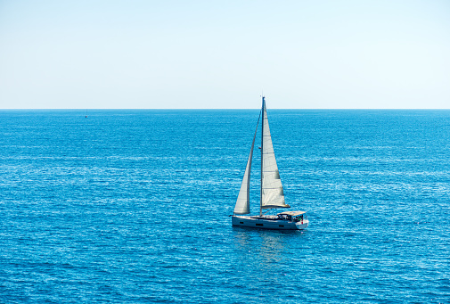 One sailing boat on the blue Mediterranean sea, Cinque Terre, Liguria, La Spezia, Italy, Europe.