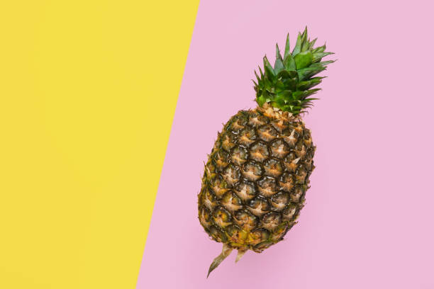 istock pineapple on yellow and pink background copy space 1351474761